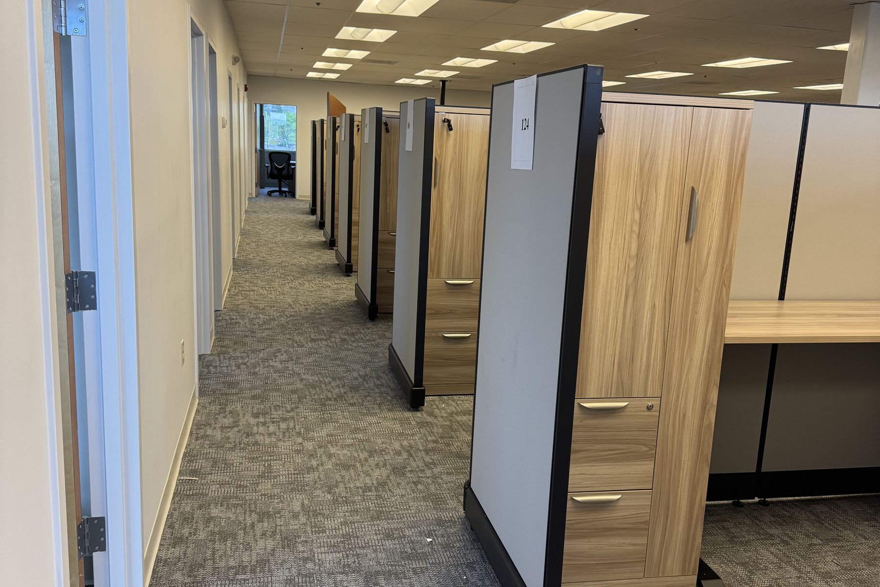 The same Tata & Howard floor plate after install, with powered workstations and integrated wardrobe storage towers built out along the private offices