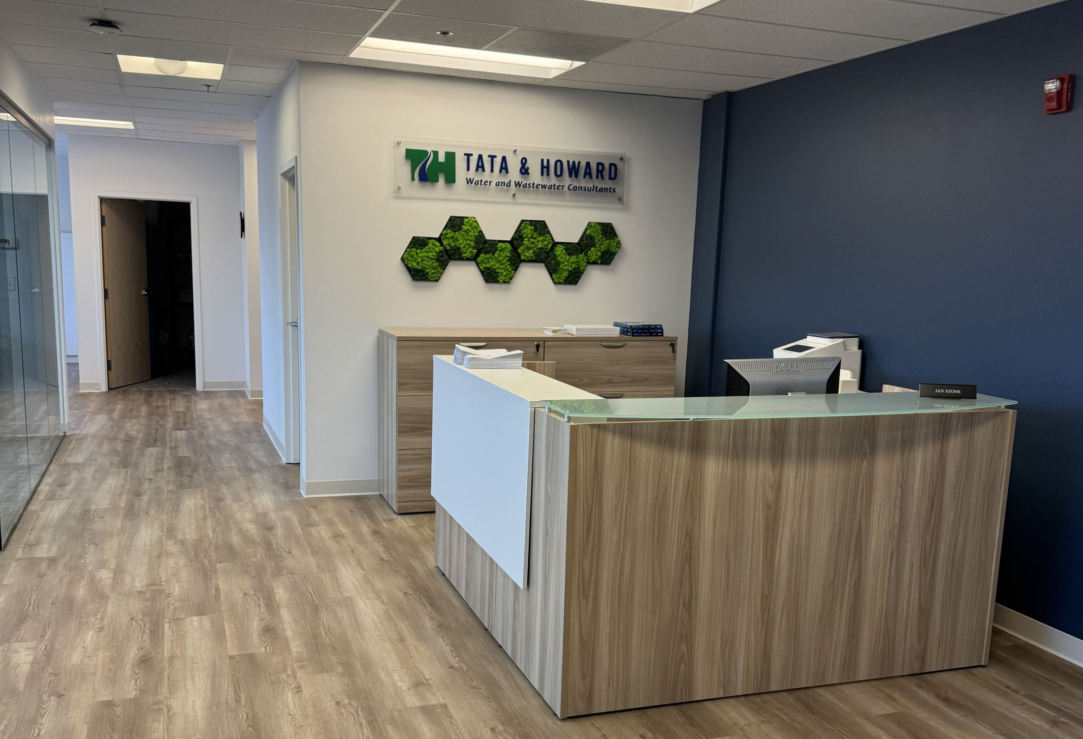 Tata & Howard reception desk in Marlborough, MA, with an acrylic-mounted logo above a preserved-moss feature wall